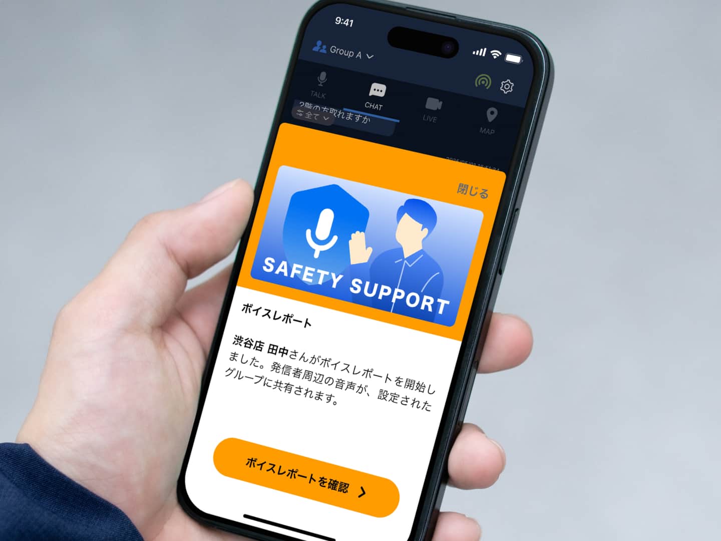 手にスマートフォンを持ちながら、Buddycomの「SAFETY SUPPORT」機能を表示している画面。