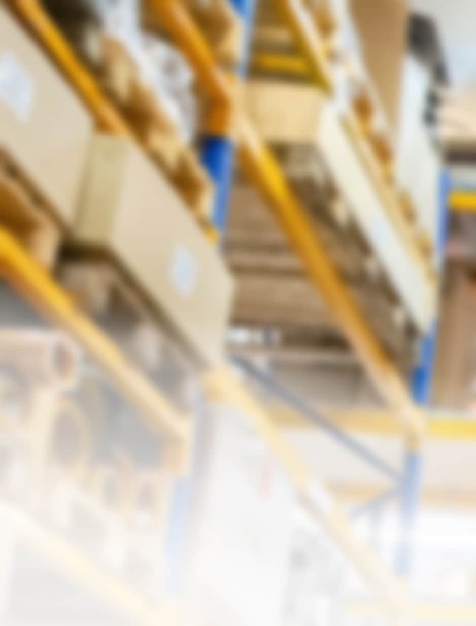 倉庫内に積まれた段ボールや資材が並んでいる様子がぼんやりと映っている。